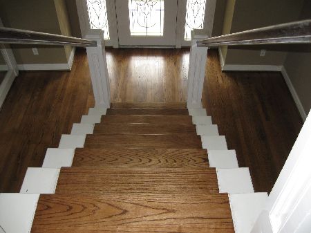 Custom oak wood stair treads installed with white painted risers in a Houston home