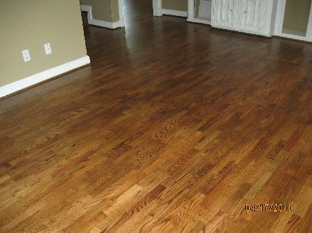 Warm chestnut red oak floor with varied plank tones in an empty Houston room with built-in cabinetry