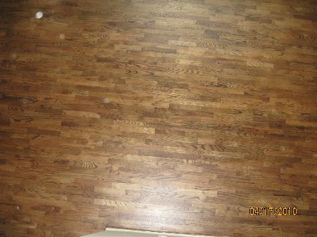 Close-up of a dark-stained oak wood floor with tight, even seams installed glue-down over a slab