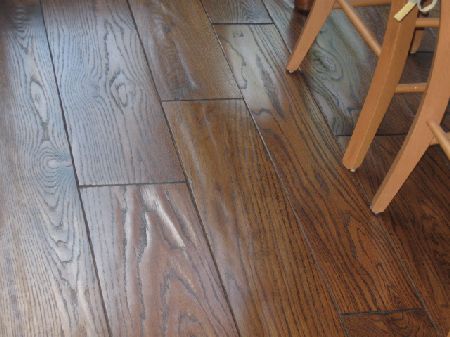 Dark hand scraped hardwood floor with oak grain in a Houston dining area